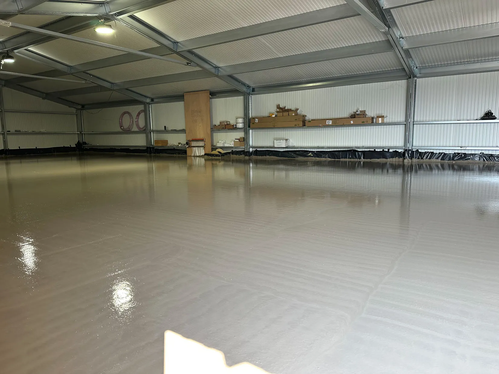 A large empty warehouse with tables and chairs.